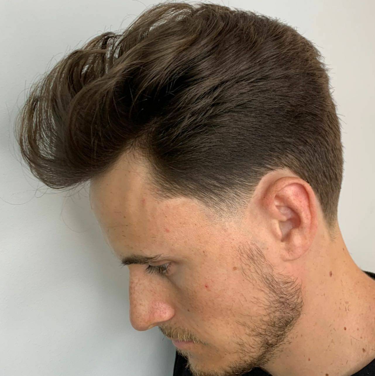 Classic high-volume pompadour combed back, side profile