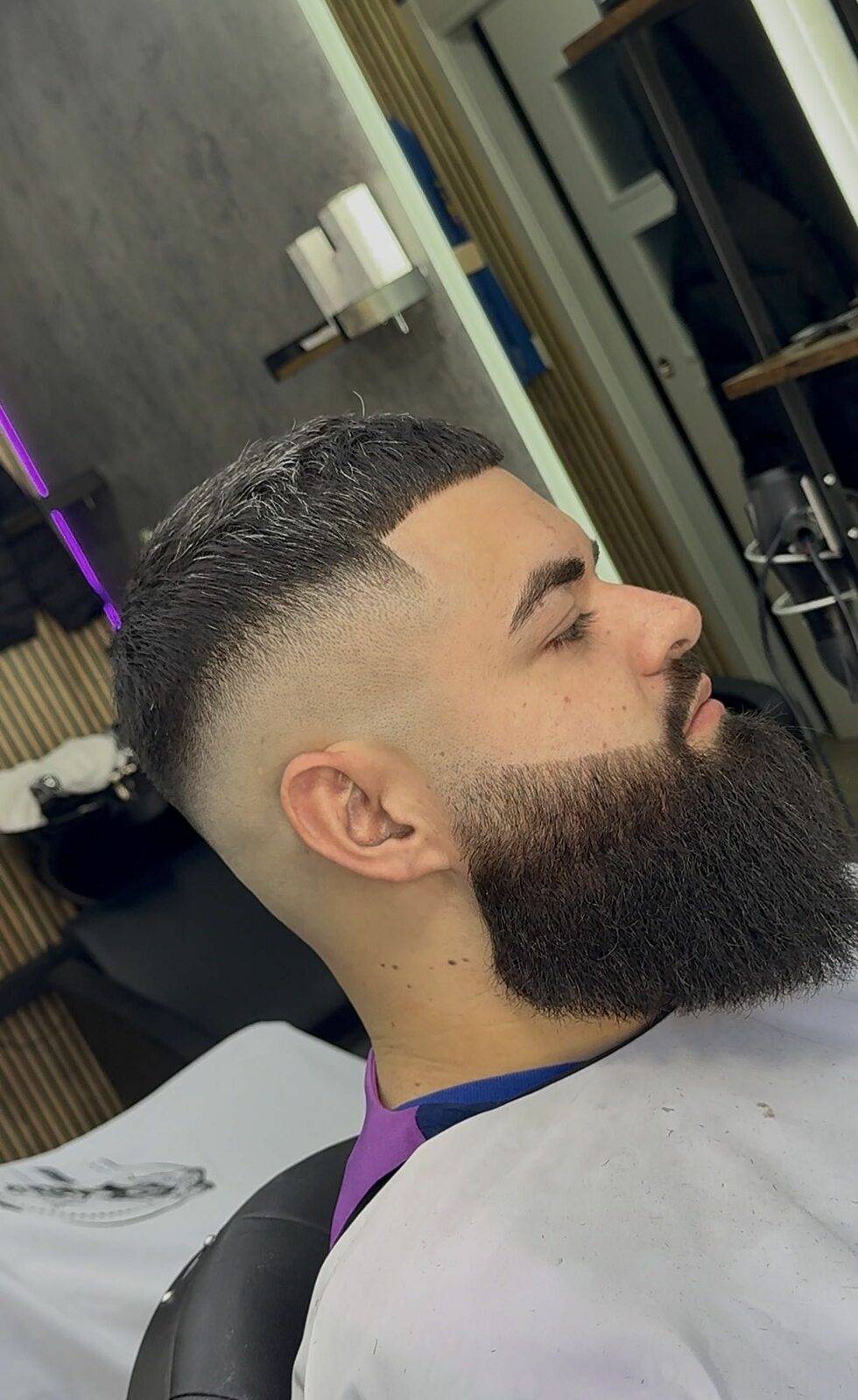 Full sculpted beard with skin fade, side profile