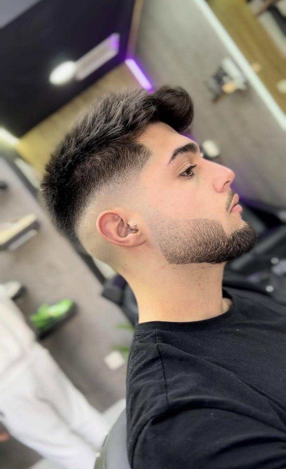 Mid fade haircut with lined-up beard, side profile